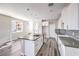 Open concept kitchen featuring white cabinets, quartz countertops, stainless steel appliances, and hardwood flooring at 8629 Ensworth St # 114, Las Vegas, NV 89123