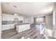 Open concept kitchen featuring white cabinets, quartz countertops, stainless steel appliances, and hardwood flooring at 8629 Ensworth St # 114, Las Vegas, NV 89123