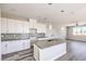 Open concept kitchen featuring white cabinets, quartz countertops, stainless steel appliances, and hardwood flooring at 8629 Ensworth St # 114, Las Vegas, NV 89123