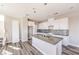 Open concept kitchen featuring white cabinets, quartz countertops, stainless steel appliances, and hardwood flooring at 8629 Ensworth St # 114, Las Vegas, NV 89123