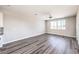 Bright, open-concept living room with wood-look floors and large windows showcasing the view at 8629 Ensworth St # 114, Las Vegas, NV 89123