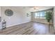 Spacious living room with modern ceiling fan, large windows, and a decorative wine rack creating a bright and welcoming atmosphere at 8629 Ensworth St # 114, Las Vegas, NV 89123