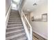 Carpeted staircase with a modern white railing and art decorations leading upstairs at 8629 Ensworth St # 114, Las Vegas, NV 89123