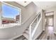 Stairway with carpeted steps, a white railing, and a large window showcasing the outside view at 8629 Ensworth St # 114, Las Vegas, NV 89123