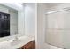 Clean bathroom with a shower, white sink, wooden cabinets, and a bright mirror at 8798 Tom Noon Ave # 103, Las Vegas, NV 89178