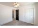 Bright bedroom with neutral carpet, white walls, ceiling fan, and double closet doors at 8798 Tom Noon Ave # 103, Las Vegas, NV 89178
