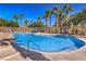 Community pool with clear blue water, a palm tree landscape, and plenty of space for lounging at 8798 Tom Noon Ave # 103, Las Vegas, NV 89178