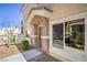 Exterior entrance featuring stucco pillars, front door, nearby walkway, and green shrubbery at 8798 Tom Noon Ave # 103, Las Vegas, NV 89178