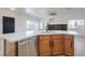 Modern kitchen island featuring a sink, dishwasher, and wooden cabinets with white countertops at 8798 Tom Noon Ave # 103, Las Vegas, NV 89178