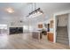 Open-concept living space with fireplace, modern lighting, stairs, and kitchen island at 8798 Tom Noon Ave # 103, Las Vegas, NV 89178