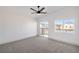Airy main bedroom with balcony access, ceiling fan, and neutral carpet at 8798 Tom Noon Ave # 103, Las Vegas, NV 89178