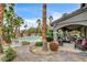 Expansive backyard with pool, patio, fire pit, and lush tropical landscaping with ample seating, ideal for entertaining and relaxation at 9108 Ghost Mountain Ave, Las Vegas, NV 89129