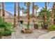 Cozy backyard firepit area with rocking chairs, perfect for relaxing evenings surrounded by lush landscaping and palm trees at 9108 Ghost Mountain Ave, Las Vegas, NV 89129