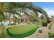 Backyard featuring a putting green, lush landscaping, a pool, and covered patio; an entertainer's dream! at 9108 Ghost Mountain Ave, Las Vegas, NV 89129