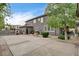 Backyard showcasing gray home exterior, mature trees, and driveway at 9108 Ghost Mountain Ave, Las Vegas, NV 89129