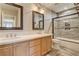 Bathroom featuring dual sinks, wood cabinets, tile floors, and updated shower at 9108 Ghost Mountain Ave, Las Vegas, NV 89129