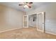 Bedroom with a ceiling fan, neutral walls, carpet, and glass paneled doors, providing a bright and airy feel at 9108 Ghost Mountain Ave, Las Vegas, NV 89129