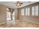 Well-lit bedroom features tile floors, neutral walls, a ceiling fan, and a sliding glass door to the outside at 9108 Ghost Mountain Ave, Las Vegas, NV 89129