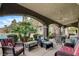 Inviting covered patio with comfortable seating, ceiling fans, and views of the sparkling pool and lush landscaping at 9108 Ghost Mountain Ave, Las Vegas, NV 89129