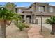 Inviting home exterior with desert landscaping, a stone walkway, and an elegant gated entrance with mature palm trees at 9108 Ghost Mountain Ave, Las Vegas, NV 89129