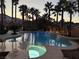 Stunning pool area with a built-in spa, decorative waterfalls, and towering palm trees creating a resort-like atmosphere at 9108 Ghost Mountain Ave, Las Vegas, NV 89129