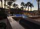 Beautiful pool area with lush landscaping, ambient lighting, and swaying palm trees for ultimate relaxation at 9108 Ghost Mountain Ave, Las Vegas, NV 89129