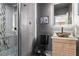 Contemporary bathroom with a modern floating vanity, decorative mirror, and glass-enclosed shower with stylish tiling at 9475 Castillana Ct, Las Vegas, NV 89147