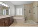 This bathroom features a soaking tub, a separate shower stall, and beautiful light fixtures at 9475 Castillana Ct, Las Vegas, NV 89147