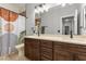 This bathroom features double sinks, dark wood cabinets, a large mirror, and a walk-in shower at 9475 Castillana Ct, Las Vegas, NV 89147