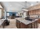 Open concept kitchen with large island, granite countertops, modern appliances, and eat-in dining at 9475 Castillana Ct, Las Vegas, NV 89147