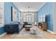 Comfortable living room with blue walls, sectional sofa, a TV, and plenty of natural light at 9475 Castillana Ct, Las Vegas, NV 89147