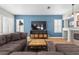 Cozy living room with a large gray couch, wooden coffee table, fireplace, and blue accent wall for a relaxed atmosphere at 9475 Castillana Ct, Las Vegas, NV 89147