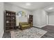 Cozy sitting room with neutral walls, hardwood floors, bookshelf, and an arched window looking outside at 9475 Castillana Ct, Las Vegas, NV 89147