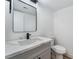 Modern bathroom features a gray vanity, a quartz countertop, a black faucet, a black-framed mirror, and a toilet at 1009 N Tenaya Way, Las Vegas, NV 89128