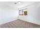 Bright bedroom featuring neutral carpet, a large window, and a modern ceiling light at 1009 N Tenaya Way, Las Vegas, NV 89128