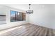 Bright dining room with wood-look floors, a modern light fixture, and a large window overlooking the pool at 1009 N Tenaya Way, Las Vegas, NV 89128