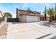 Two-story home boasts an attached two-car garage, desert landscaping, and concrete driveway on a sunny day at 1009 N Tenaya Way, Las Vegas, NV 89128