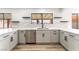 Kitchen with stainless steel appliances, white cabinets, quartz countertops, and a view of the backyard at 1009 N Tenaya Way, Las Vegas, NV 89128