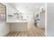 Modern kitchen features white cabinets, sleek countertops, a breakfast bar, and light wood-look flooring at 1009 N Tenaya Way, Las Vegas, NV 89128