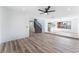 Spacious living room with wood-look flooring, a staircase, a window, and an open view to the kitchen at 1009 N Tenaya Way, Las Vegas, NV 89128