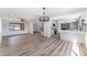 Open-concept living space featuring a living room, dining area, staircase, and kitchen with wood-look flooring at 1009 N Tenaya Way, Las Vegas, NV 89128