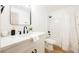 Bright bathroom showcasing a white single sink vanity, toilet, and a shower with white curtain at 10229 Birch Bluff Ln, Las Vegas, NV 89145