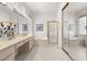 Bright bathroom with double sinks, a soaking tub, and mirrored closet doors at 10548 Findlay Ave, Las Vegas, NV 89134