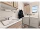 Functional laundry room with a sink, washer, dryer, and built-in cabinets at 10548 Findlay Ave, Las Vegas, NV 89134