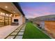 A modern backyard features a patio, green lawn, and desert landscaping, perfect for outdoor living at 10794 White Clay Dr, Las Vegas, NV 89135