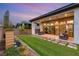 Outdoor living space featuring a covered patio with furniture and a well-manicured backyard with pavers and artificial turf at 10794 White Clay Dr, Las Vegas, NV 89135