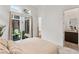Bright bedroom with carpet, ensuite bathroom, and sliding glass doors leading to the private patio with seating at 10794 White Clay Dr, Las Vegas, NV 89135