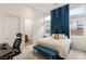 Well-lit bedroom featuring stylish decor, a padded headboard, and a view of the backyard through clerestory windows at 10794 White Clay Dr, Las Vegas, NV 89135