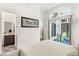 Bright bedroom with plush carpet, ensuite bathroom, and sliding glass doors to a private patio with seating at 10794 White Clay Dr, Las Vegas, NV 89135