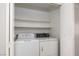 Small laundry room with stacked washer and dryer and built-in shelving at 1333 Pinto Rock Ln # 202, Las Vegas, NV 89128